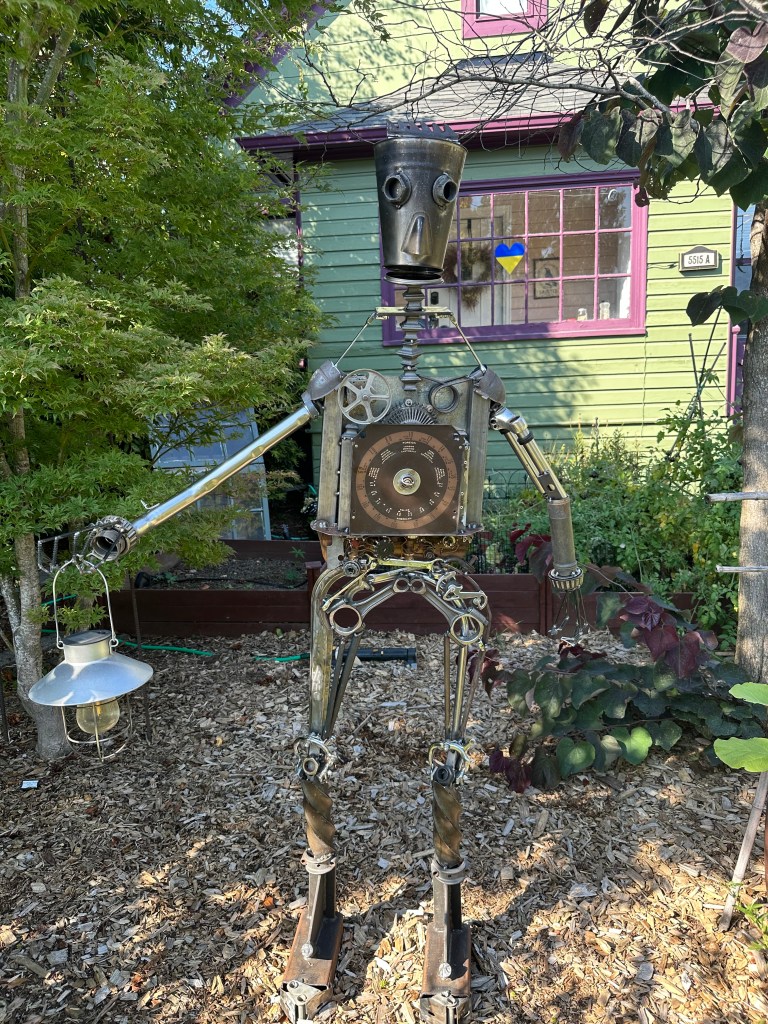 Metal man with upside down coffee pot for a head.